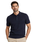 Hombre con polo azul marino de manga corta y textura estructurada, estilo casual y elegante para moda masculina premium disponible en varias tallas y colores.