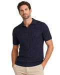Hombre viste polo azul marino de punto canalé con manga corta, estilo casual y elegante, ideal para moda masculina premium en tejidos cómodos y de calidad.
