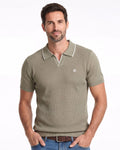 Hombre modelo con polo manga corta verde terracota de tejido premium con cuello en V y detalle blanco, estilo casual elegante para moda masculina de calidad.