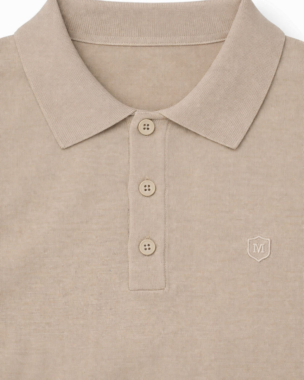 Detalle del suéter beige de punto con cuello polo y tres botones, tejido 100% algodón, ideal para moda masculina premium de alta calidad.