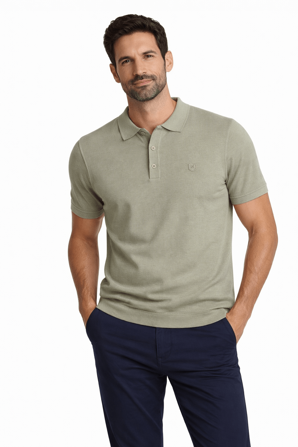Hombre con suéter de punto tipo polo en verde celadón, manga corta y botones, combinado con pantalón azul oscuro, look casual de moda masculina premium.