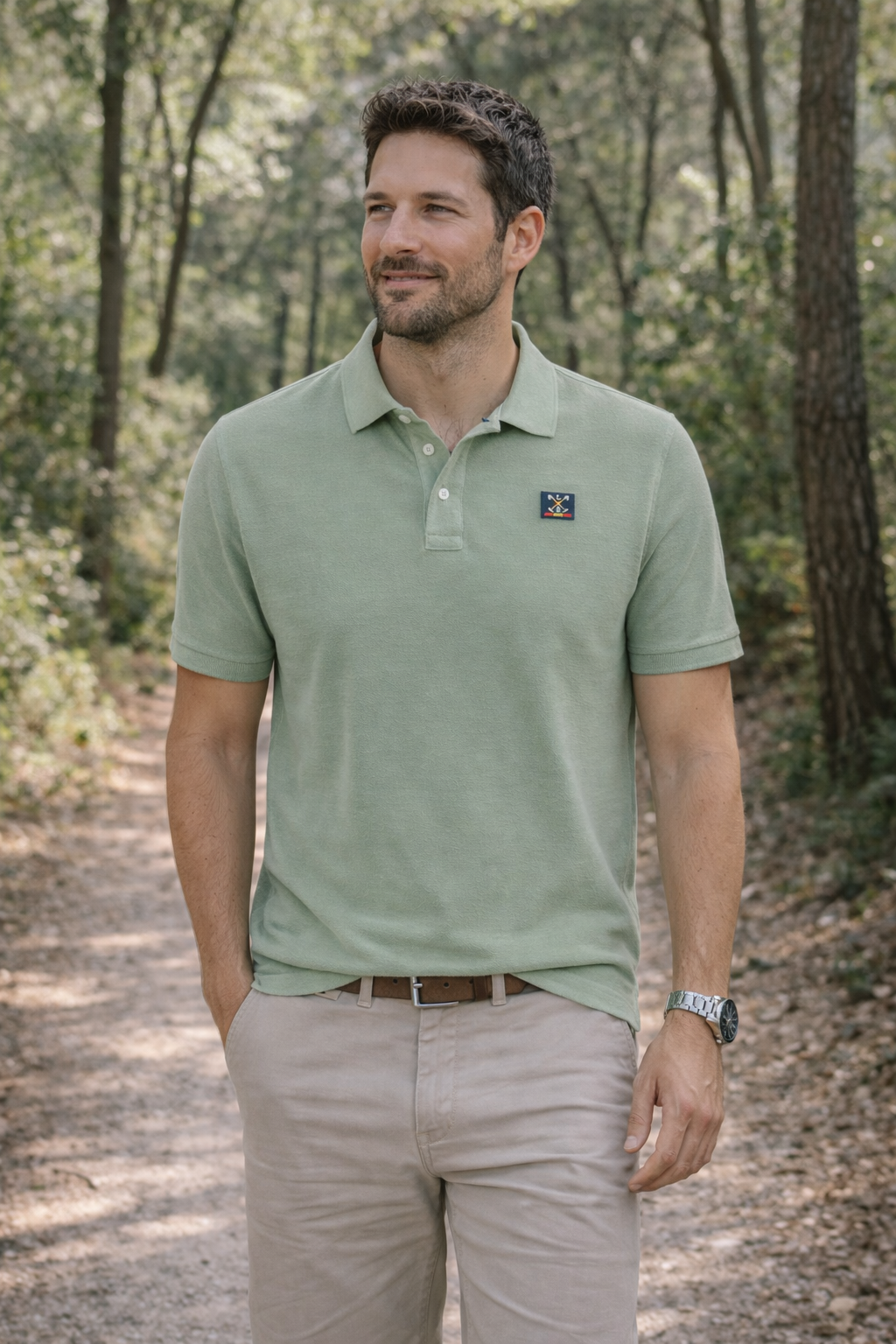Hombre elegante con polo verde palo de algodón y elastano, estilo casual y cómodo, perfecto para moda masculina premium en colores suaves, en un entorno natural.