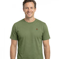 Hombre vistiendo camiseta verde de algodón con cuello caja y manga corta, diseño básico y logo pequeño en el pecho, ideal para moda masculina premium de calidad.