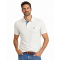 Hombre con polo blanco de algodón y elastano, diseño premium con detalle bordado discreto, estilo casual y elegante para moda masculina de calidad.