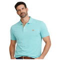 Hombre con polo azul turquesa de algodón y elastano, diseño premium con detalle bordado en el pecho, ideal para moda masculina de calidad y estilo casual elegante.