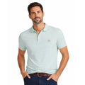Hombre con polo estilo premium en color verde gris suave, tejido de algodón con elastano, detalle bordado y diseño clásico para moda masculina de calidad.