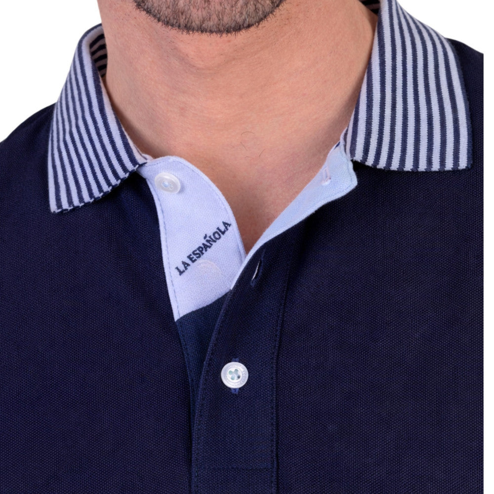 Detalle del cuello de polo azul marino para hombre con tejido de algodón y elastano, con cuello a rayas y botonería frontal, moda masculina premium.